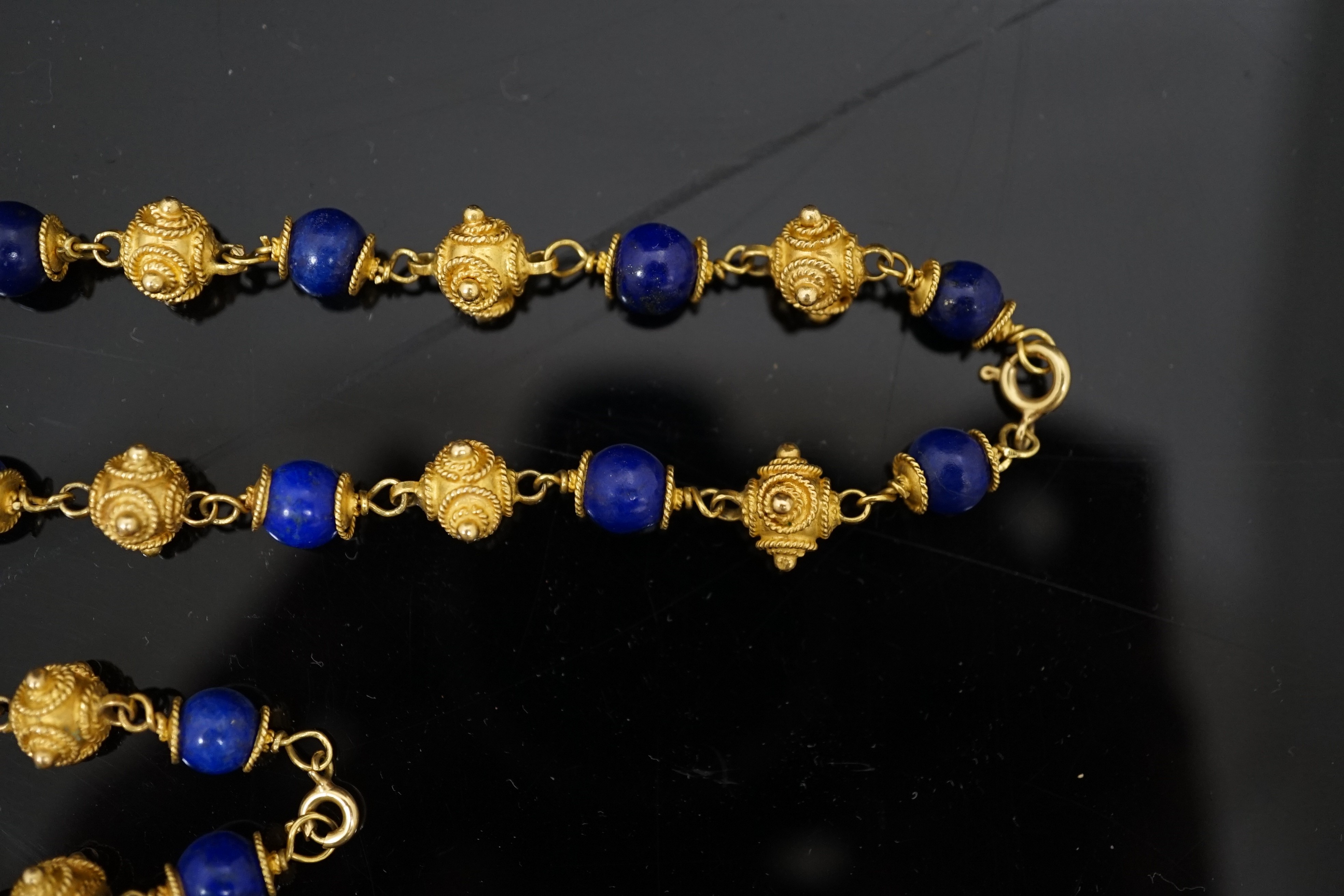 A 20th century Middle Eastern high carat gold canetile work bead and lapis lazuli bead set necklace and matching bracelet